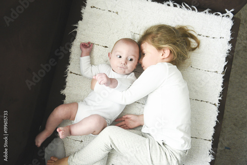 sister girl hugs newborn brother
