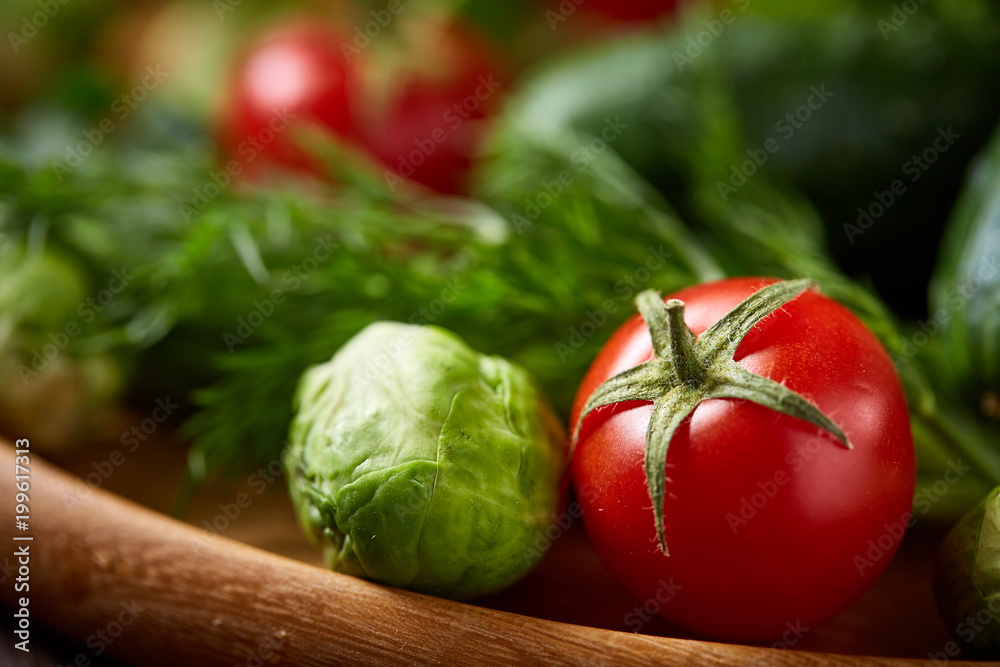 Vegetarian still life of fresh vegetables on wooden plate over rustic background, close-up, flat lay. Vegetarian still life of fresh vegetables on wooden plate over rustic background, close-up, flat lay.