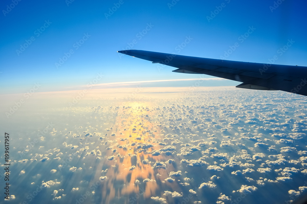 Obraz premium Airplane wing and view of clouds below