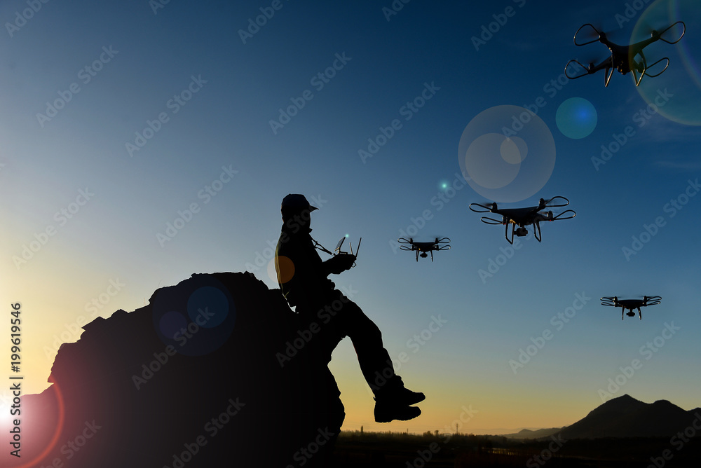 Fototapeta premium Man flying a drone in the mountains using a controller
