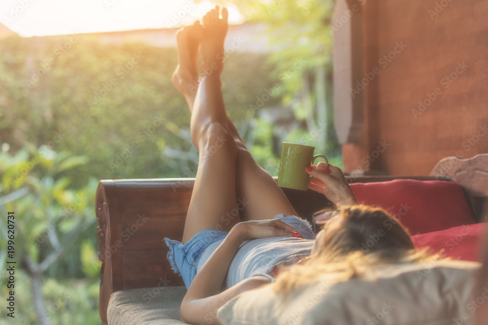 Girl enjoying morning coffee on the porch. - obrazy, fototapety, plakaty 