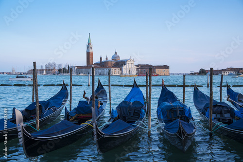 Venice, Italy: gondolas moored in the San Marco basin and the San Giorgio Maggiore church. Italian landscape.