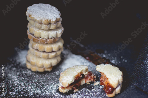 Stack of homemade vanilla jam cookies, on dark background, with copy space photo