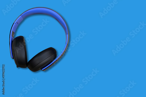 headphones on a blue surface background, space for text