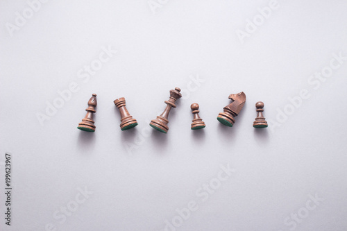 Chess game figures on grey background , top view, flat lay