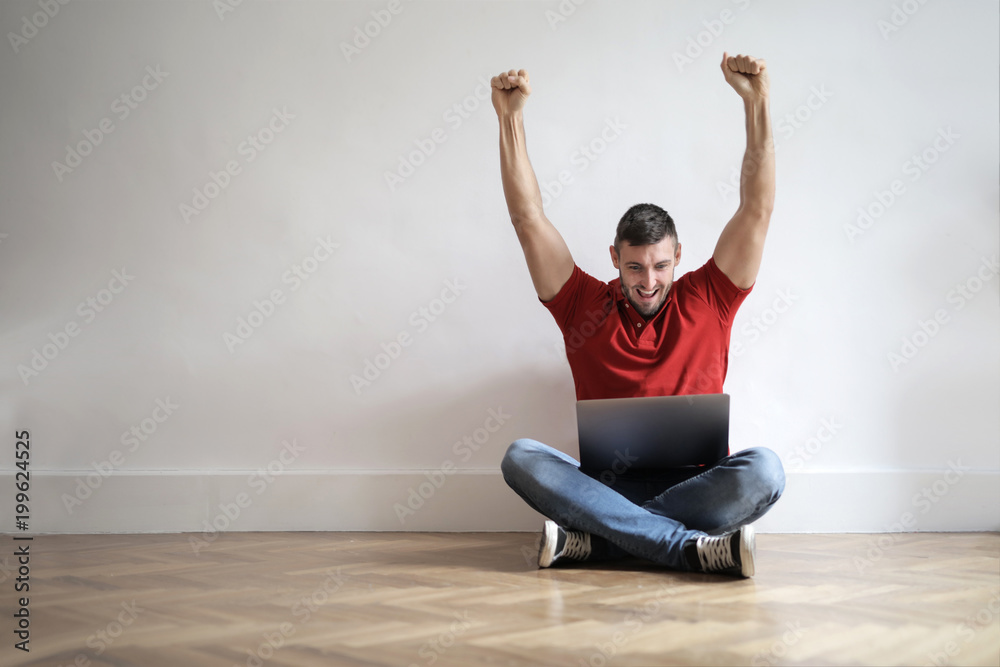 Obraz premium Jubilant man using a laptop