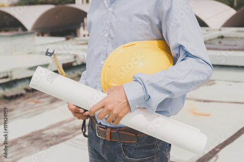 Engineers agree to work together,Architecture at construction site,Consultation for workers,engineer holding white helmet and drawing,Concept foreman,technician man holding safety hat