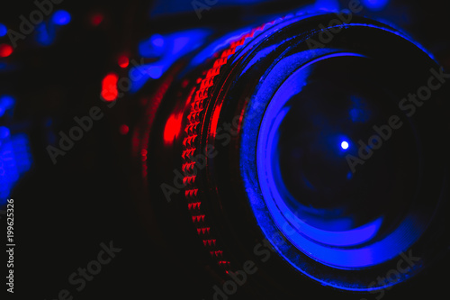 Professional camera and lens illuminated in red and blue