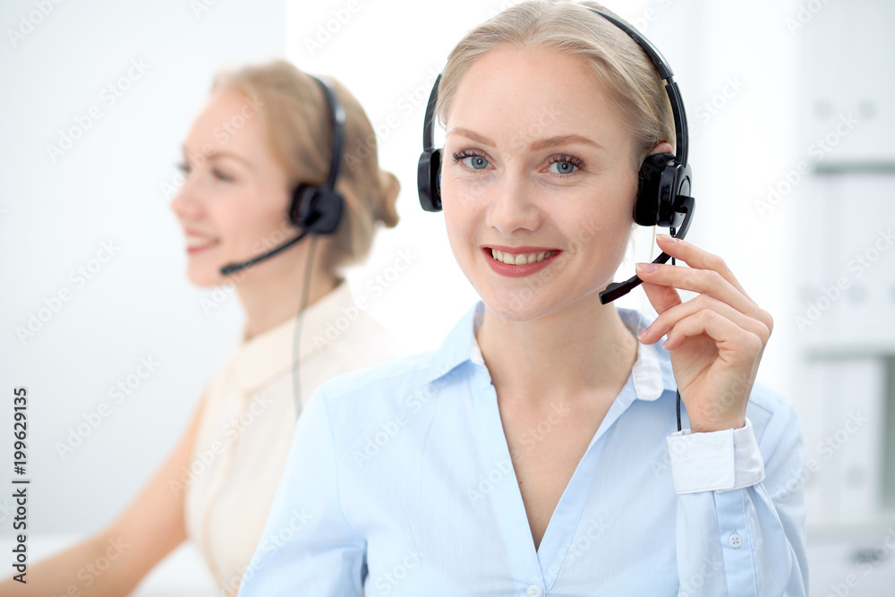 Image of bright call center. Focus on young beautiful woman in a headset Image of bright call center. Focus on young beautiful woman in a headset