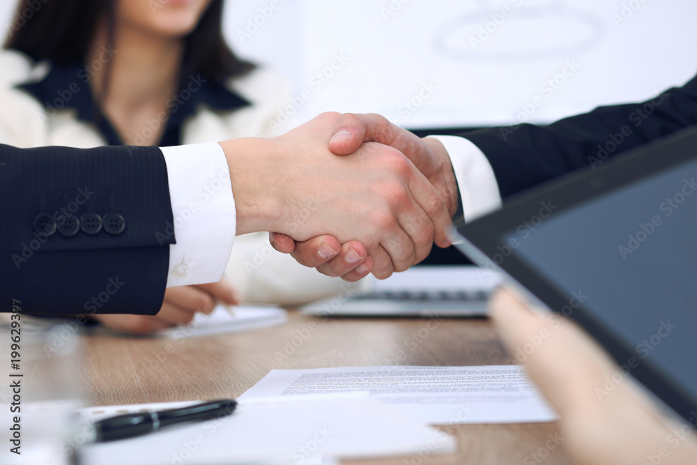 Close up of business people shaking hands at meeting or negotiation in the office. Partners are satisfied because signing contract Close up of business people shaking hands at meeting or negotiation in the office. Partners are satisfied because signing contract