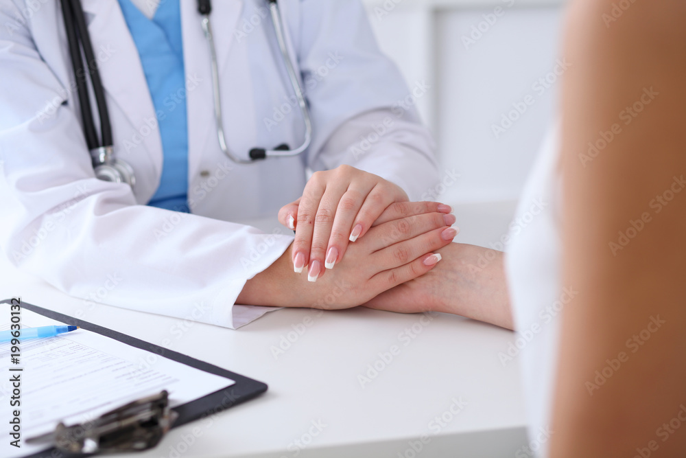 Close up of doctor hands reassuring her female patient Close up of doctor hands reassuring her female patient