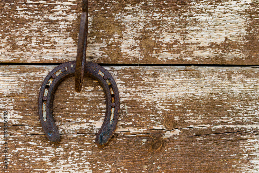 Horseshoe hanging on a wooden wall Horseshoe hanging on a wooden wall