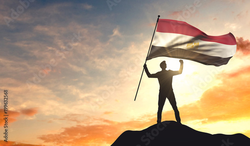 Canvas Print Egypt flag being waved by a man celebrating success at the top of a mountain