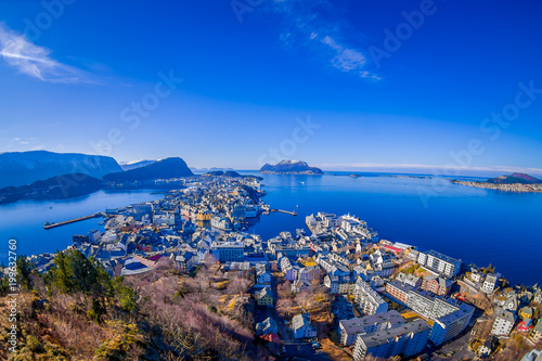 Amazing outdoor view of colorful buildings from the mountain Aksla at the city of Alesund with a huge mountain behind