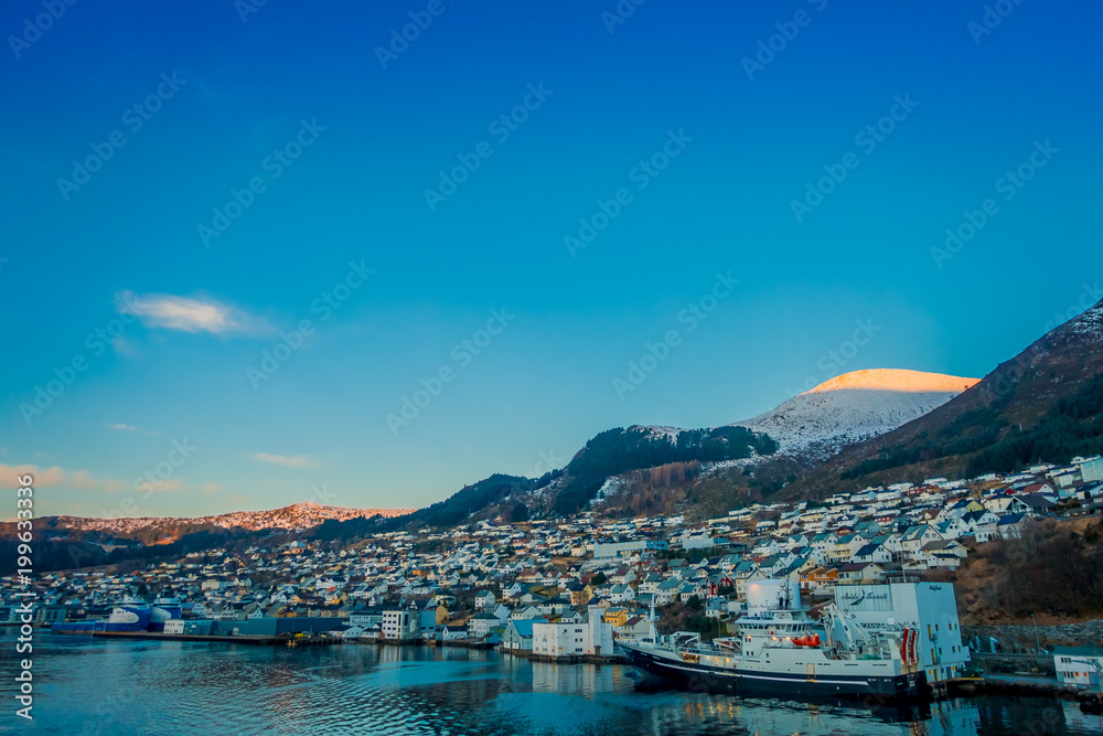 Beautiful outdoor view of colorful buildings from the mountain Aksla at the city of Hurtigruten with two huge mountains behind, Norway