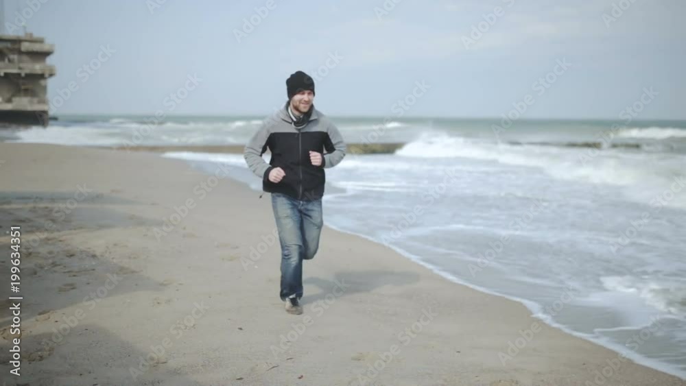 man runs around the sea, on an abandoned beach man runs around the sea, on an abandoned beach