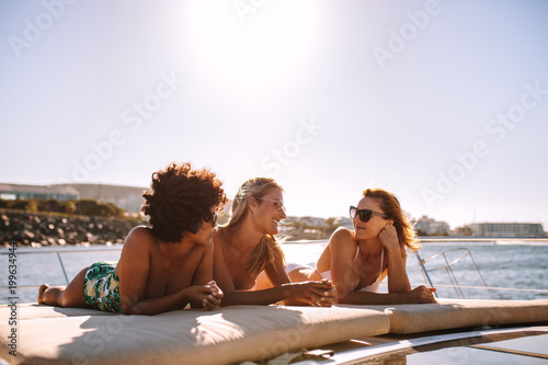 Female friends relaxing on a yacht deck © Jacob Lund