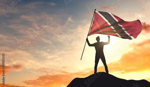 Trinidad and tobago flag being waved by a man celebrating success at the top of a mountain. 3D Rendering photo