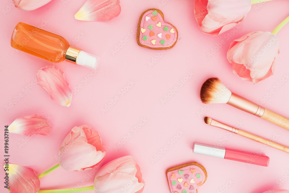 Frame with tulips flowers and cosmetics, cookies on pink pastel background. Flat lay, top view. Spring time Frame with tulips flowers and cosmetics, cookies on pink pastel background. Flat lay, top view. Spring time
