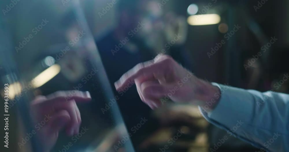 A man in his own studio uses a glass monitor with holography to design, navigate and build. Concept of: navigation, future, technology, engineer.