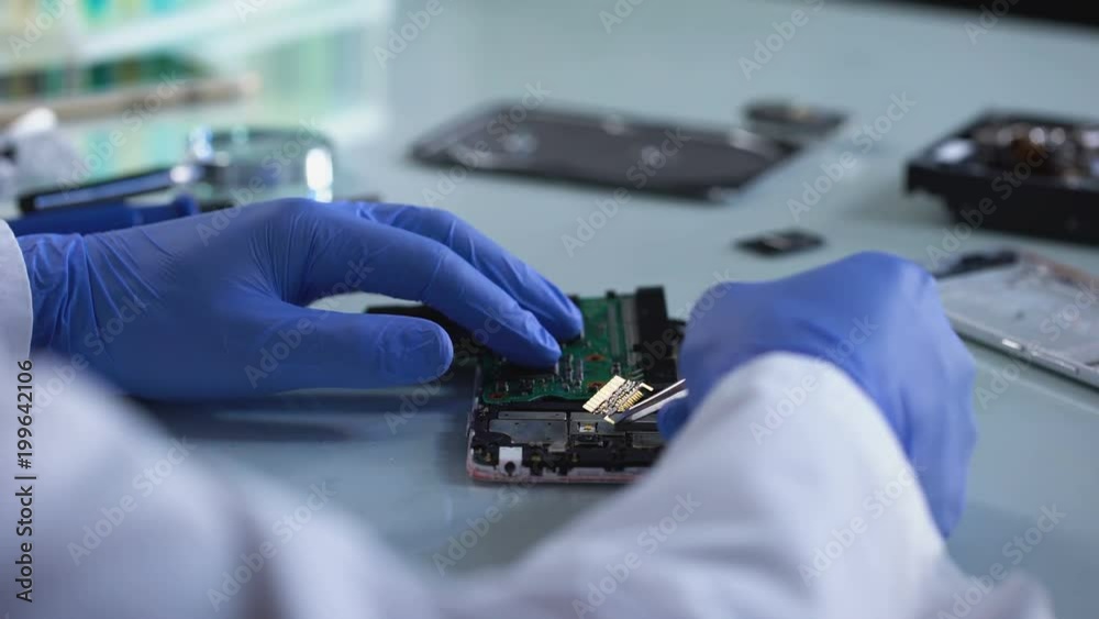 Lab worker analyzing computer part, forensic science experiment, information
