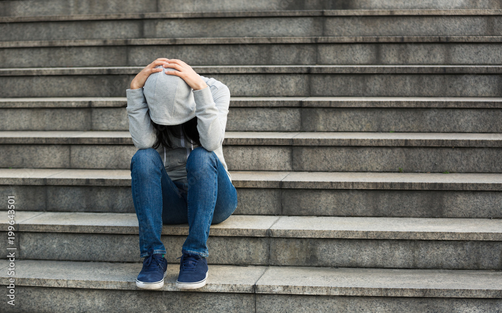 Upset woman sitting alone on city stairs Upset woman sitting alone on city stairs