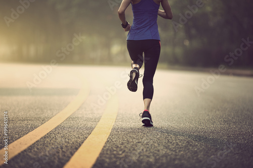 Fototapeta Naklejka Na Ścianę i Meble -  Fitness sportswoman running on sunrise trail
