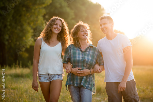 Outdoor portrait of smiling happy senior mother with her children