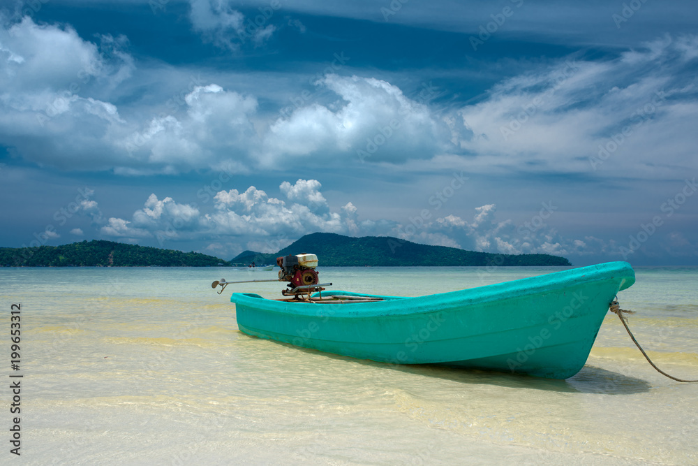 Turquoise motor boat on the beach with engine on the back, clear water mountain in the background. Beautiful weather with blue sky. Koh Rong Samloem island, Cambodia Turquoise motor boat on the beach with engine on the back, clear water mountain in the background. Beautiful weather with blue sky. Koh Rong Samloem island, Cambodia