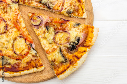 Cutting board with piece of pizza. Close up. Copy space.