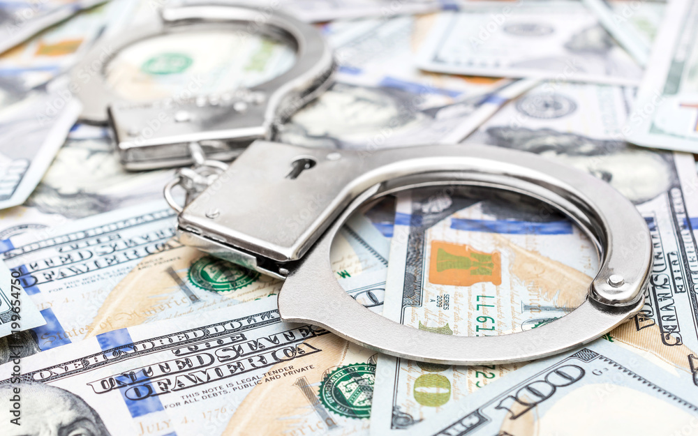 Handcuffs on the background of dollar bills. Handcuffs on the background of dollar bills.