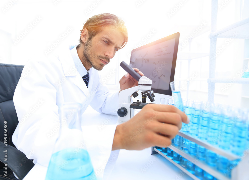 Chemist looking at test-tubes with blue liquids Chemist looking at test-tubes with blue liquids