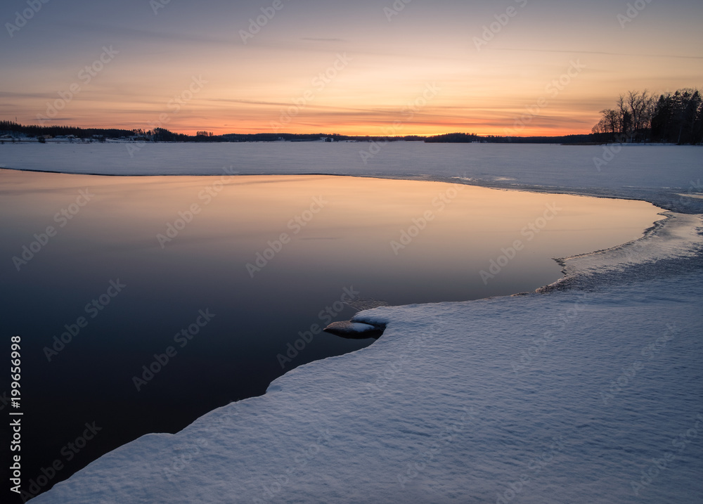 Scenic landscape with melted lake an sunset at evening in Finland