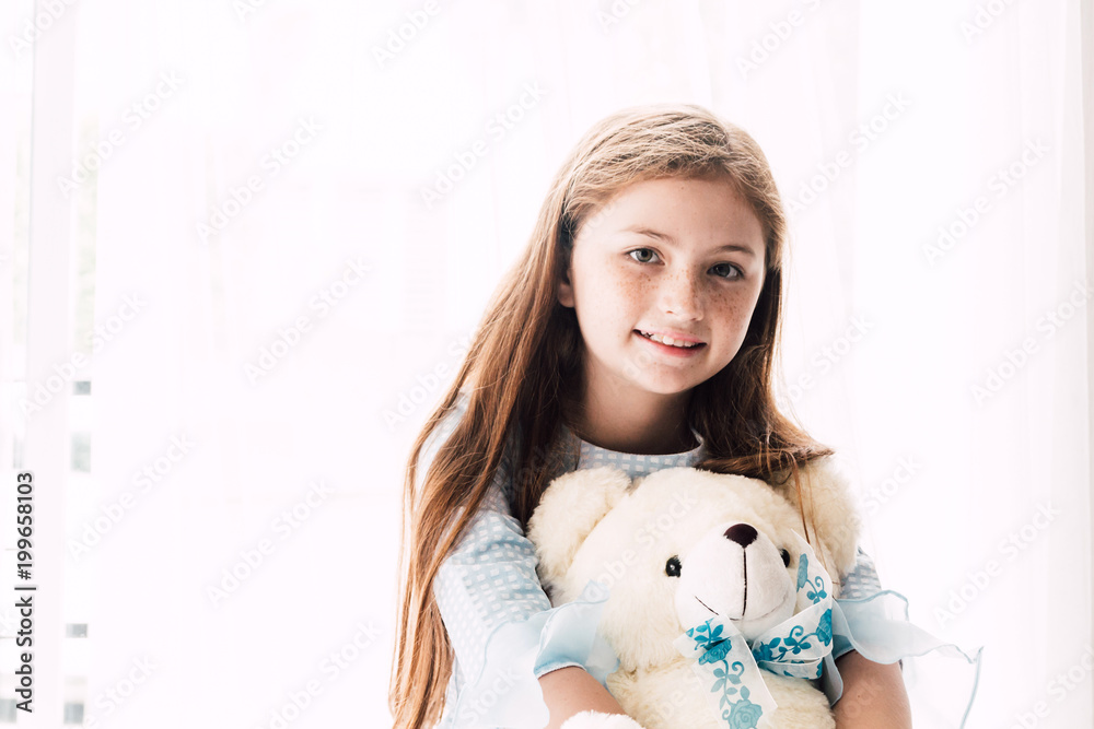 Cute little girl kid hugging teddy bears on the bed at home Cute little girl kid hugging teddy bears on the bed at home