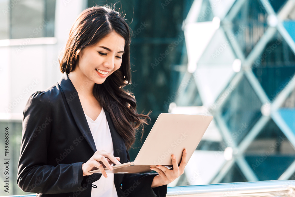 Happy successful businesswoman using a laptop computer Happy successful businesswoman using a laptop computer