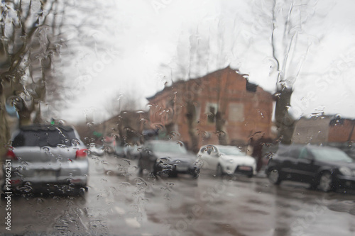 rain on the city street through a car windshield. Rain drops on window, rainy weather