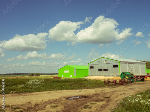 Farm hangars in pure sunny field. Agricultural background.
