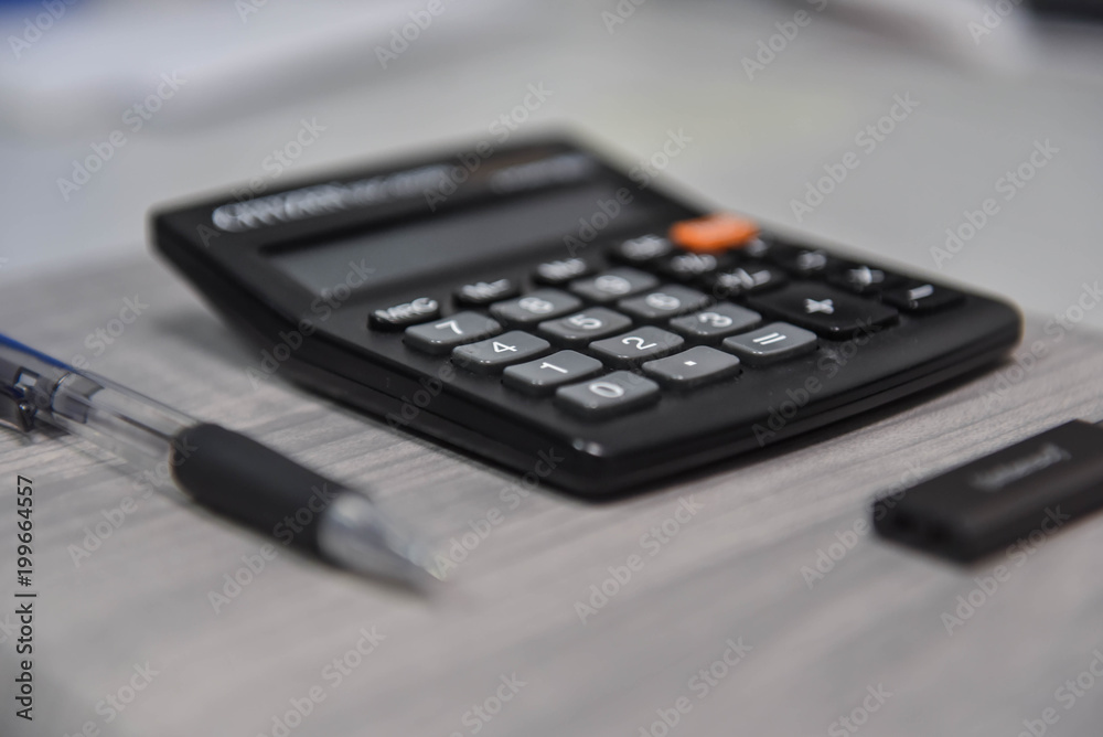 Calculator, pen and USB stick on the notebook in the office Calculator, pen and USB stick on the notebook in the office