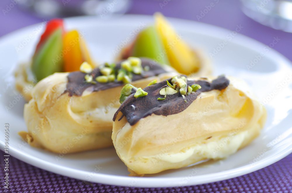 choux pastry with chocolate and pistachio topping or eclair