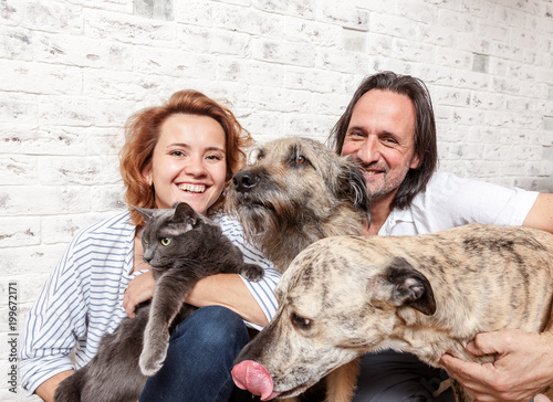 Attractive man and his young wife with pets, two dogs and a cat, a family portrait