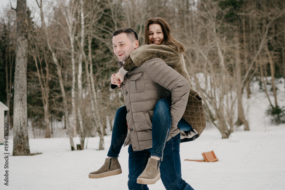 Fototapeta premium Happy gorgeous young women riding a strong man on the countryside