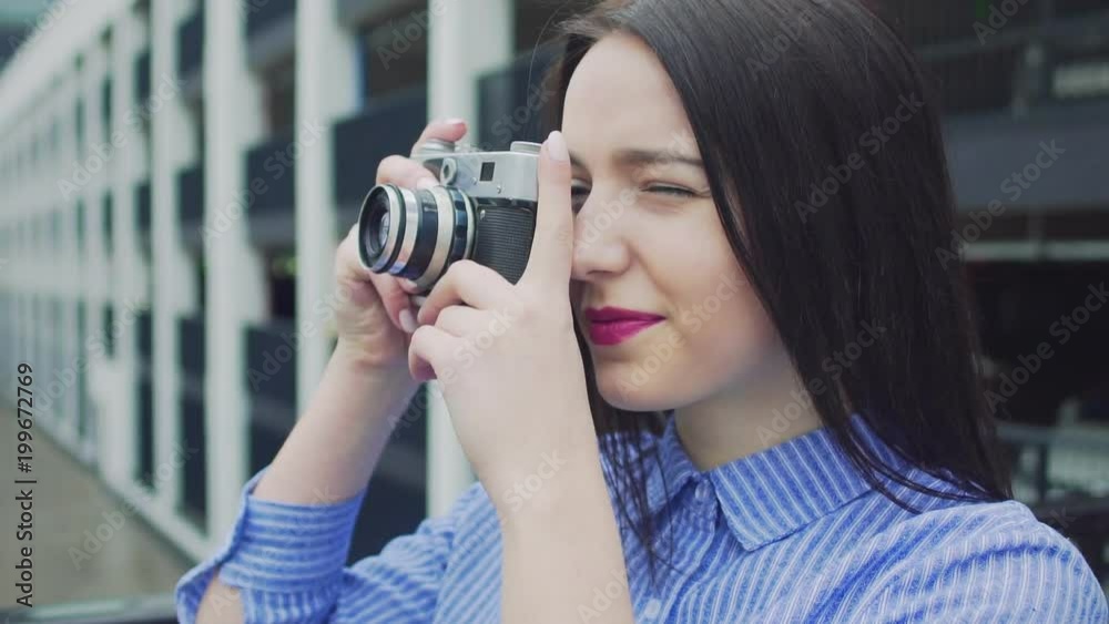 Beautiful brunette hipster girl shooting with retro camera Beautiful brunette hipster girl shooting with retro camera