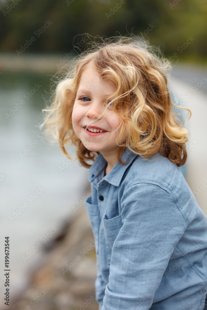 Happy child with long blond hair enjoying the holidays Happy child with long blond hair enjoying the holidays