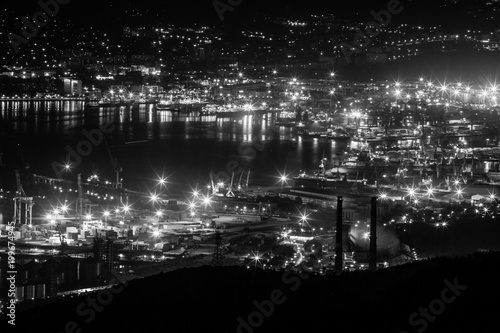 Night view of the Novorossiysk town and the bay at the Black Sea coast. Lights glow at night and make feeling of science fiction landscape.