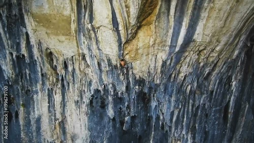 Cliff climber young man on vertical wall, Prohodna Cave, Bulgaria photo