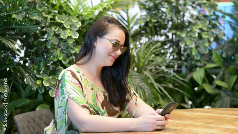young woman sitting in cafe with mobile phone in hands young woman sitting in cafe with mobile phone in hands