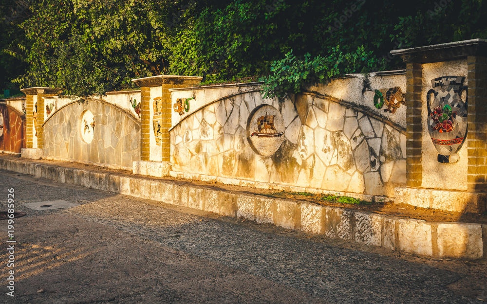 Ancient Roman style wall with mosaic panels at sunset in Castle Hill park in Nice, Cote d'Azur, France