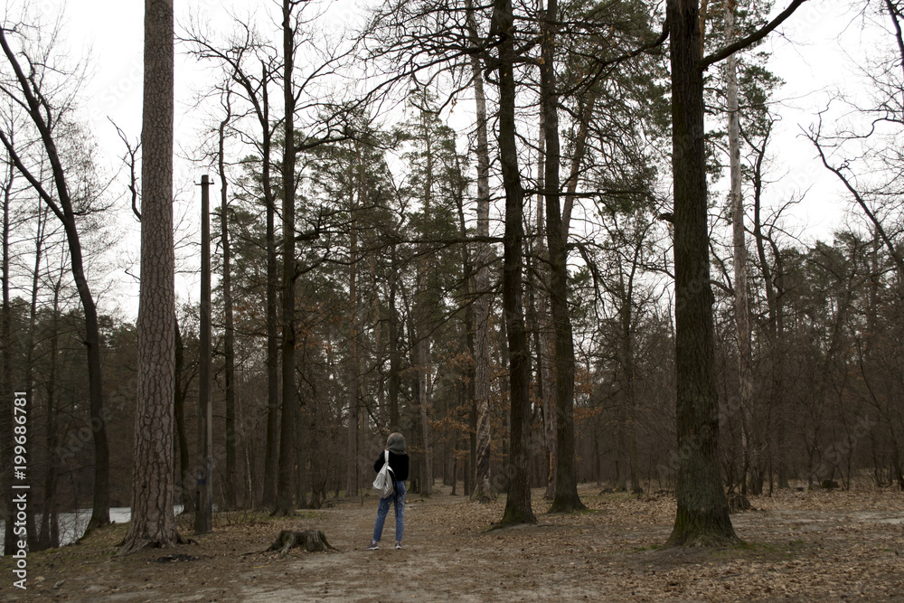 A woman is walking in the woods.