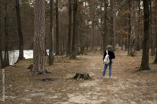 A woman is walking in the woods.