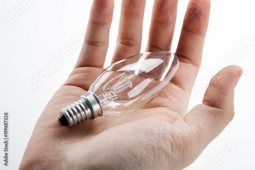 Men's hand holds a bulb and the symbol of the idea